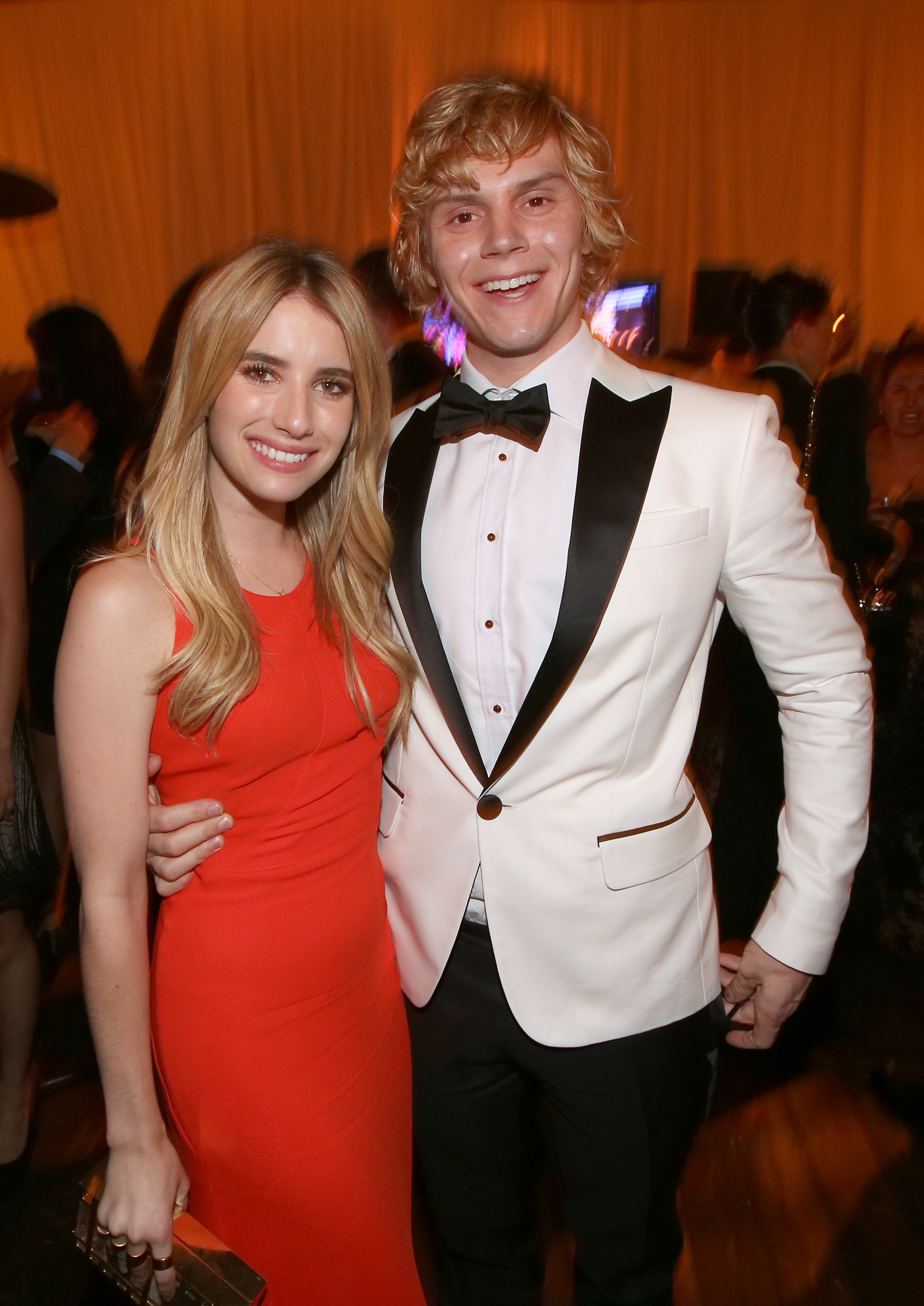 Emma Roberts e Evan Peters abraçados em um evento