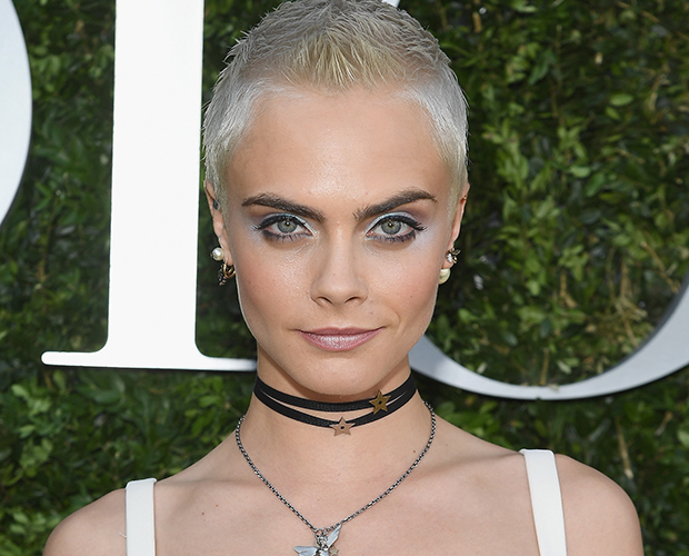 cara delevingne cabelo curto com expressão séria e posando para foto.