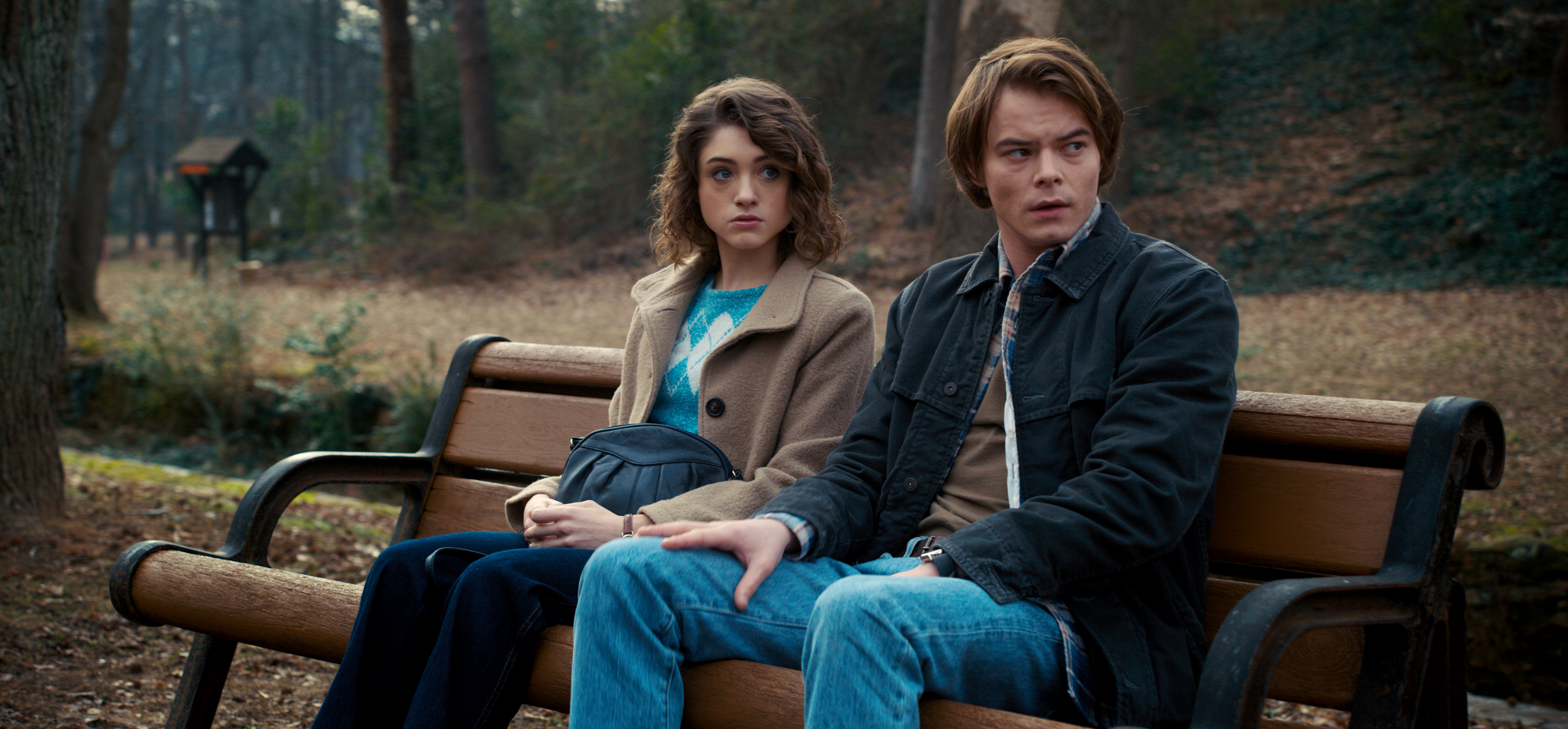 Nancy e Jonathan em Stranger Things sentados em um banco no parque