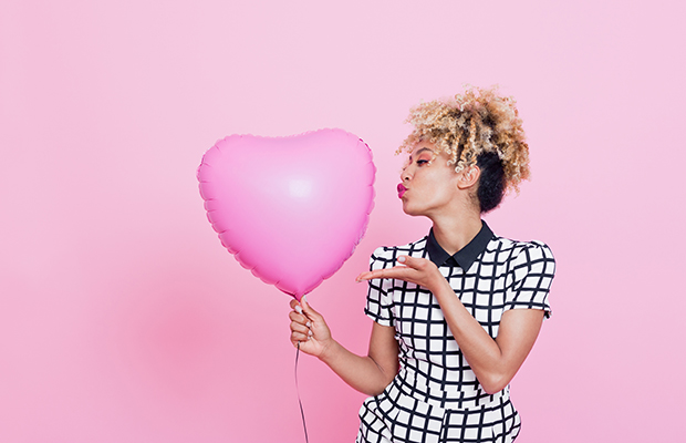 Garota negra com um balão de coração