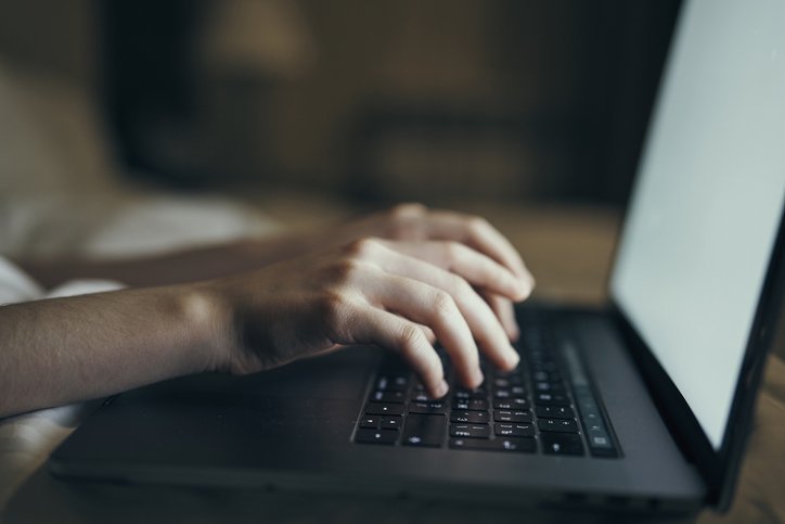 Mãos digitando no teclado de um notebook