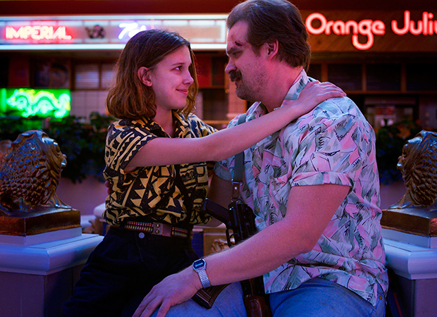 Eleven (Millie Bobby Brown) e Hopper (David Harbour) quase abraçados em Stranger Things