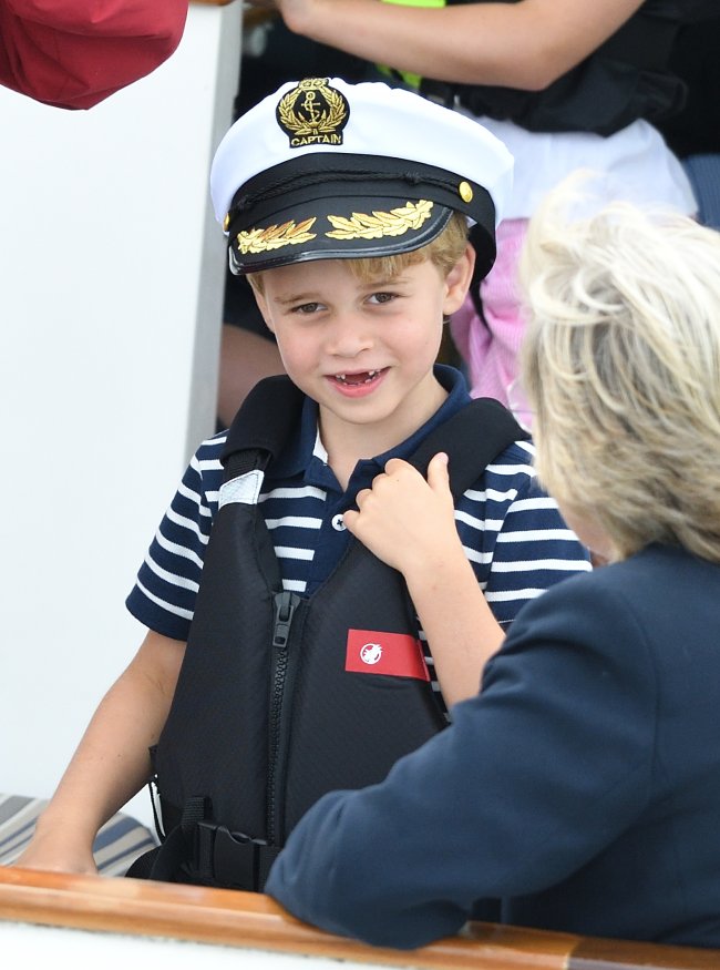 principe-george-marinheiro Prince George sorrindo e vestindo roupa que lembra estilo marinheiro e chapéu de marinheiro no evento esportivo King's Cup Regatta;