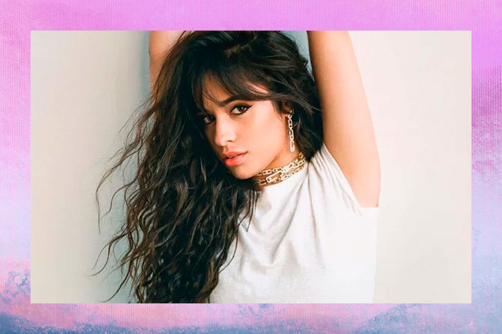 Camila Cabello com os braços levantados