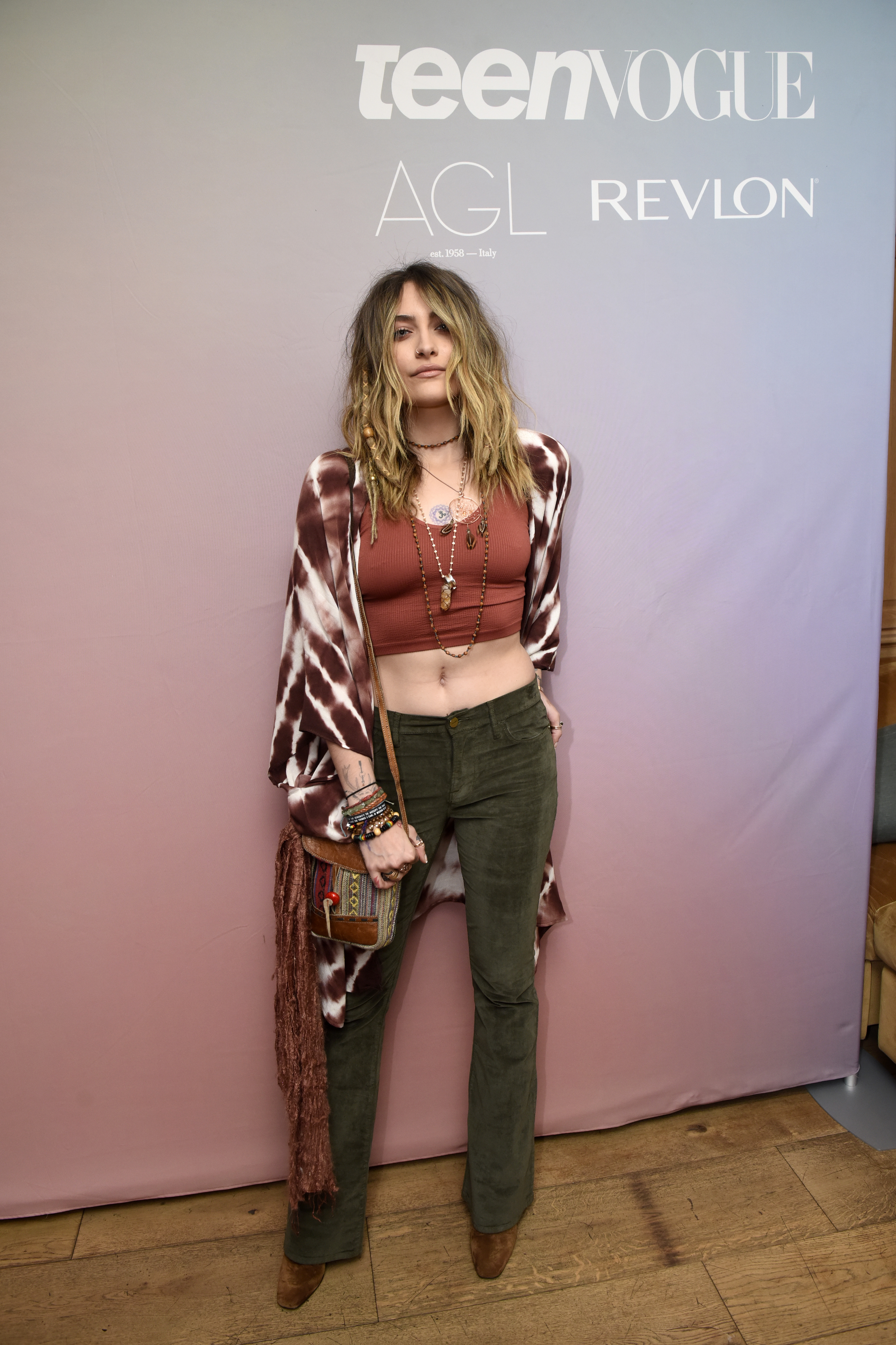 look-do-dia-paris-jackson Paris Jackson usando kimono tie-dye, bolsa de franjas, top cropped marrom, calça de veludo verde e bota marrom