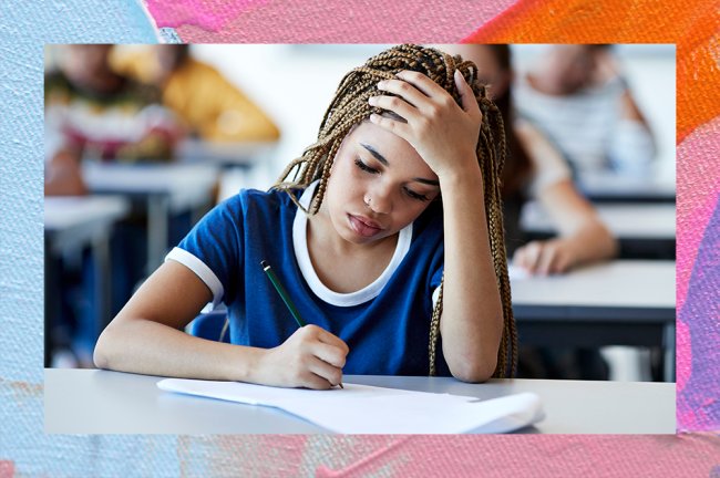 enem A imagem mostra uma menina negra, com o cabelo longo e escuro em tranças. Ela está usando o que parece ser um uniforme escolar, com uma camiseta azul com a ponta das mangas e a gola brancas. Ela está sentada em uma mesa, escrevendo em uma folha com uma mão enquanto a outra apoia a cabeça, como se estivesse pensando. No fundo, mesmo que levemente desfocado, é possível ver outras carteiras e pessoas atrás dela, como se estivesse numa escola ou numa sala de prova.