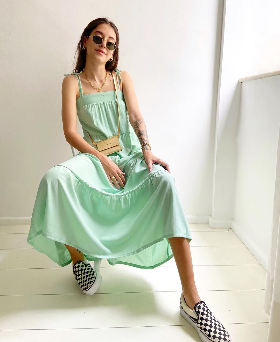 A influenciadora Luíza Schiavini usando vestido verde pastel com tênis slip on preto e branco