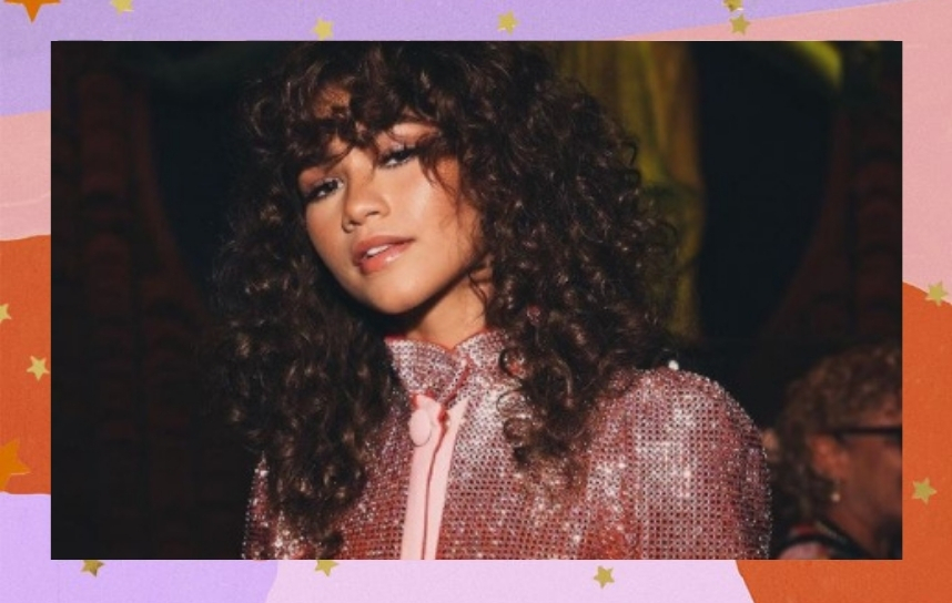 Zendaya de cabelo solto, cacheado, olhando para a câmera