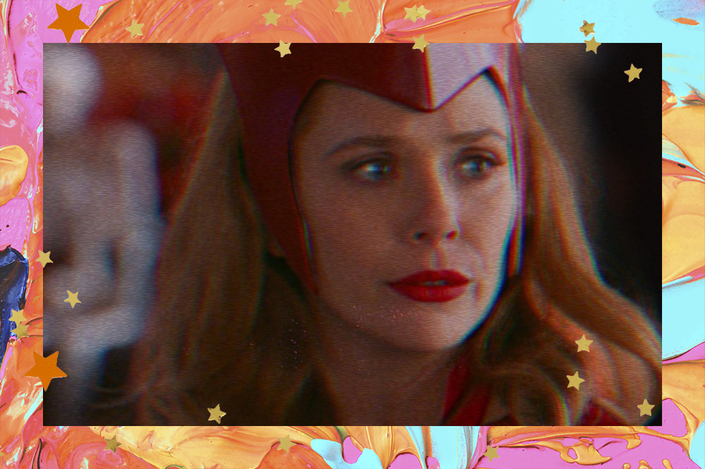 personagem Wanda com acessório de cabeça e batom vermelhos. Ela olha séria para o lado