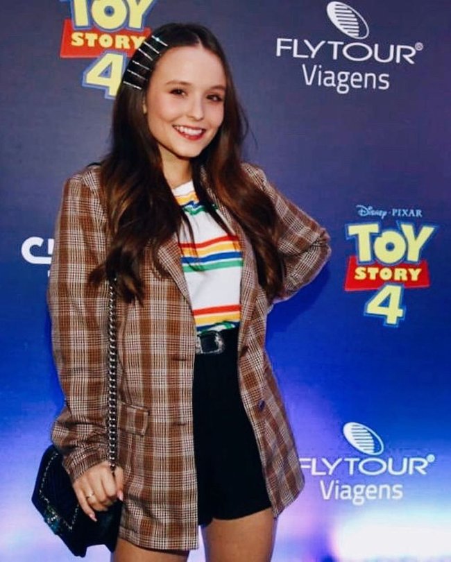 Larissa Manoela posa em pré-estreia do filme Toy Story 4, usando uma camiseta branca com listras, short jeans e blazer xadrez