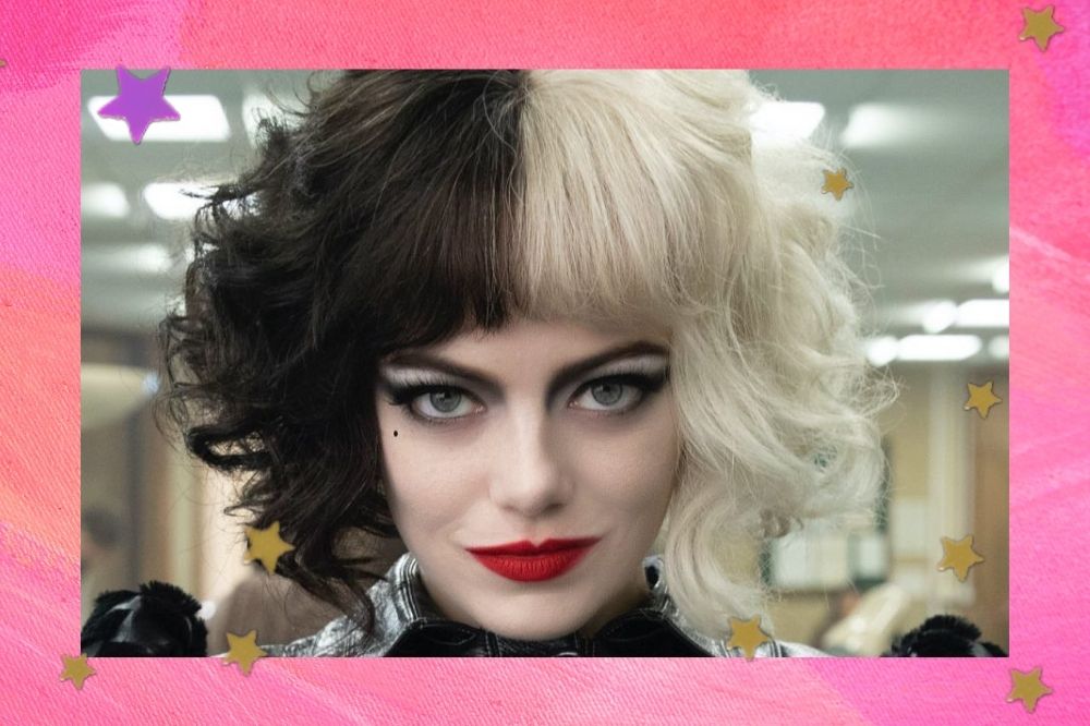 Emma Stone no filme Cruella, vestida como a personagem, usando peruca de cabelo na cor preta e branca, com expressão séria. Na imagem só conseguimos ver seu rosto.