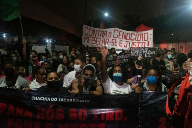 Moradores da favela do Jacarezinho protestam conta chacina e seguram faixas com os escritos: 