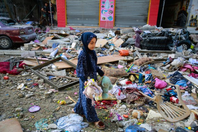 Israel x Palestina: as guerras, o conflito em Gaza e a cobertura midiática Uma garotinha está no meio de escombros, em uma rua de Gaza, com o que restou de alguns ursinhos de pelúcia destruídos pela guerra