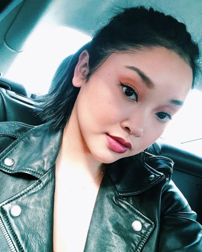 Selfie da atriz Lana Condor. Ela usa uma jaqueta de couro preta, cabelo meio preso e maquigem com sombra marrom, delineado e batom nude. Ela olha para a câmera e não sorri.