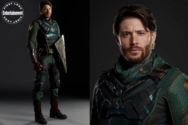 Imagens de divulgação de Jensen Ackles como o Soldier Boy, de The Boys. Ele veste um figurino de super-heróis verde escuro e leva na mão um escudo prata