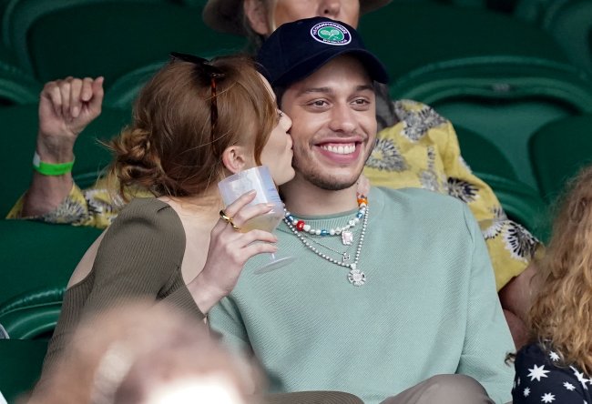 Phoebe Dynevor da beijo na bochecha de Pete Davidson, que exibe um largo sorriso