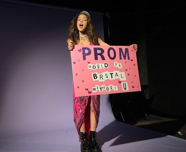 mtv-ema Olivia Rodrigo em imagem de divulgação do show virtual Sour Prom. Ela usa vestido rosa, com tiara de princesa e segura cartaz rosa.