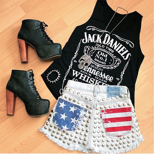 Foto de um look com regata preta com estampa Jack Daniels, short com estampa da bandeira dos Estados Unidos e sapato LITA.