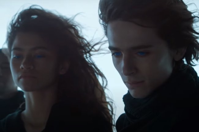zendaya e timothee duna dune Zendaya e Timothée Chalamet em cena de Duna; os dois estão com olhos azuis brilhantes e com o vento batendo nos cabelos; eles tem expressões sérias