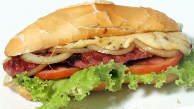 23 provas de que pão é uma das coisas mais maravilhosas que existem Foto de um pão recheado com linguiça, cebola, alface, queijo e tomate