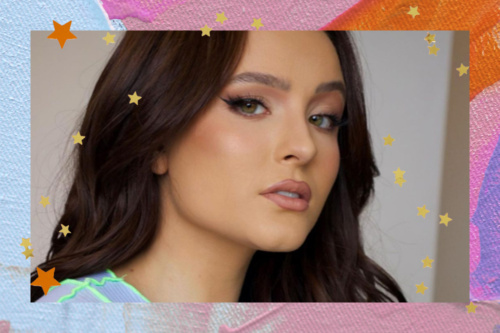 Larissa Manoela com expressão facial séria olhando para a câmera e cabelo castanho escuro solto. O fundo da montagem possui cores azul, rosa, laranja e estrelinhas douradas