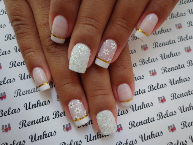 unha fitilhos dourados Foto de unhas decoradas com esmalte branco, decoração de flores no dedo anelar e fitilhos dourados.