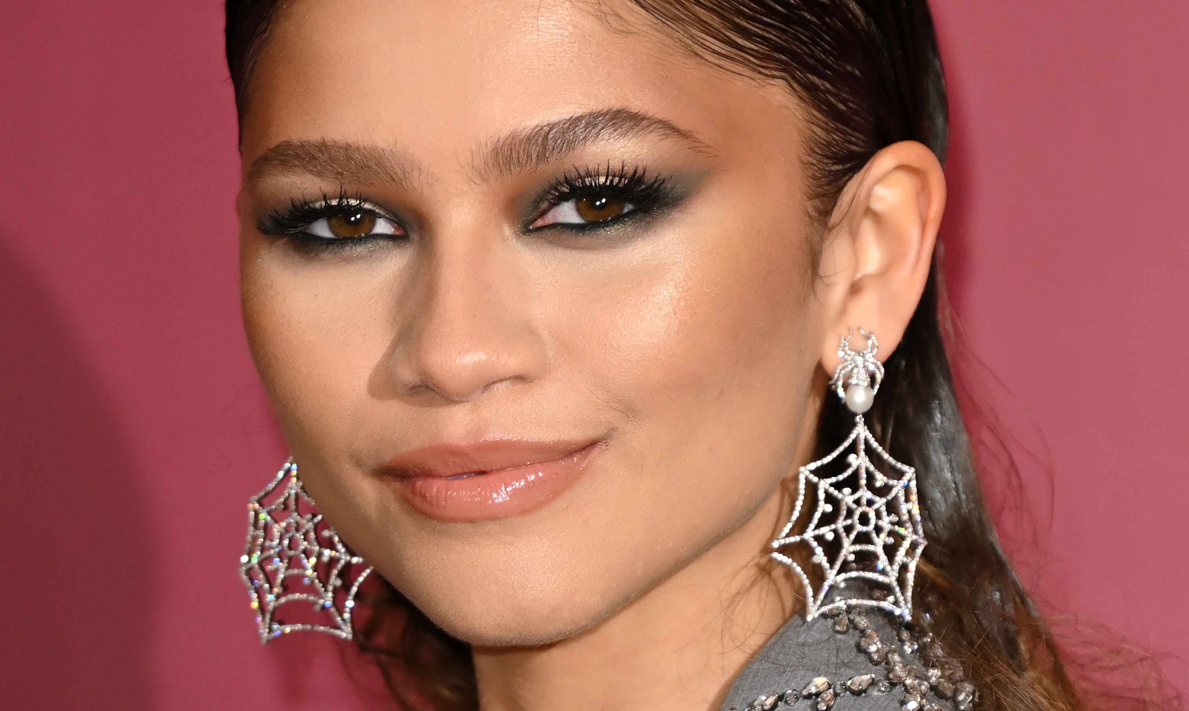 Zendaya na photocall de Homem-Aranha: Sem Volta para Casa, em Londres usando brincos que imitam teia de aranha e maquiagem com sombra preta esfumada