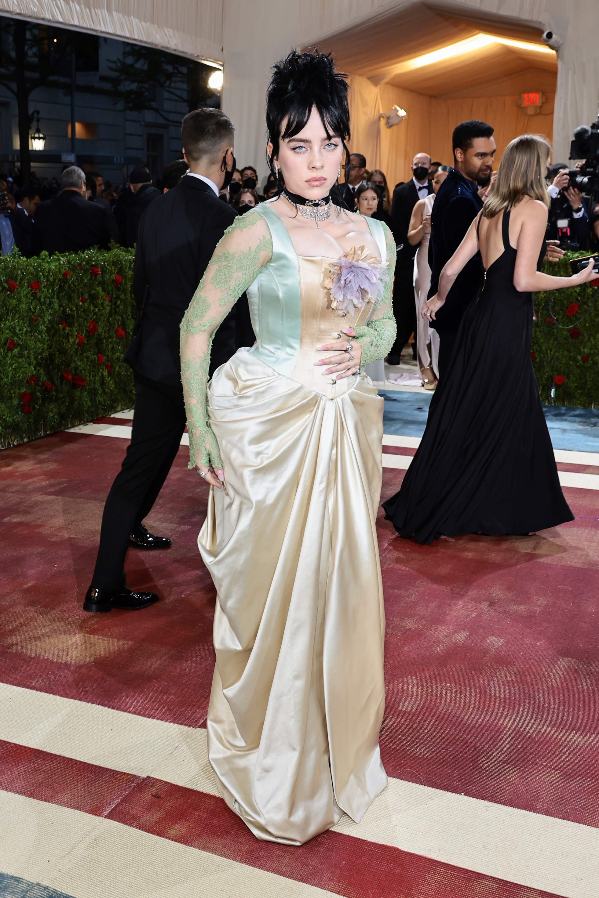 A imagem mostra Billie Eilish usando vestido azul pastel com corselete, luvas, e saia estilo cascata no tapete vermelho do MET Gala 2022, no Metropolitan Museum of Art em 02 de maio de 2022 na cidade de Nova York.