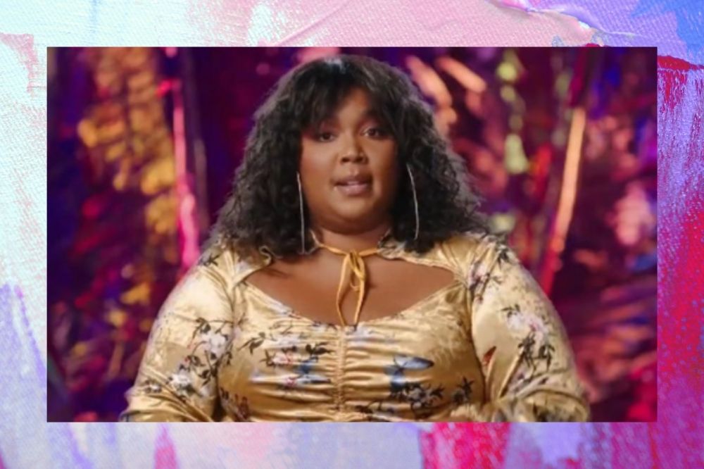 Lizzo com vestido amarelo estampado em fundo roxo.