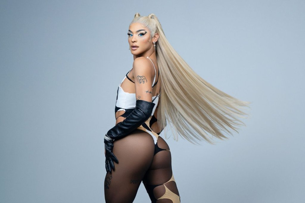 Pabllo Vittar posando para foto com roupa transparente em fundo cinza