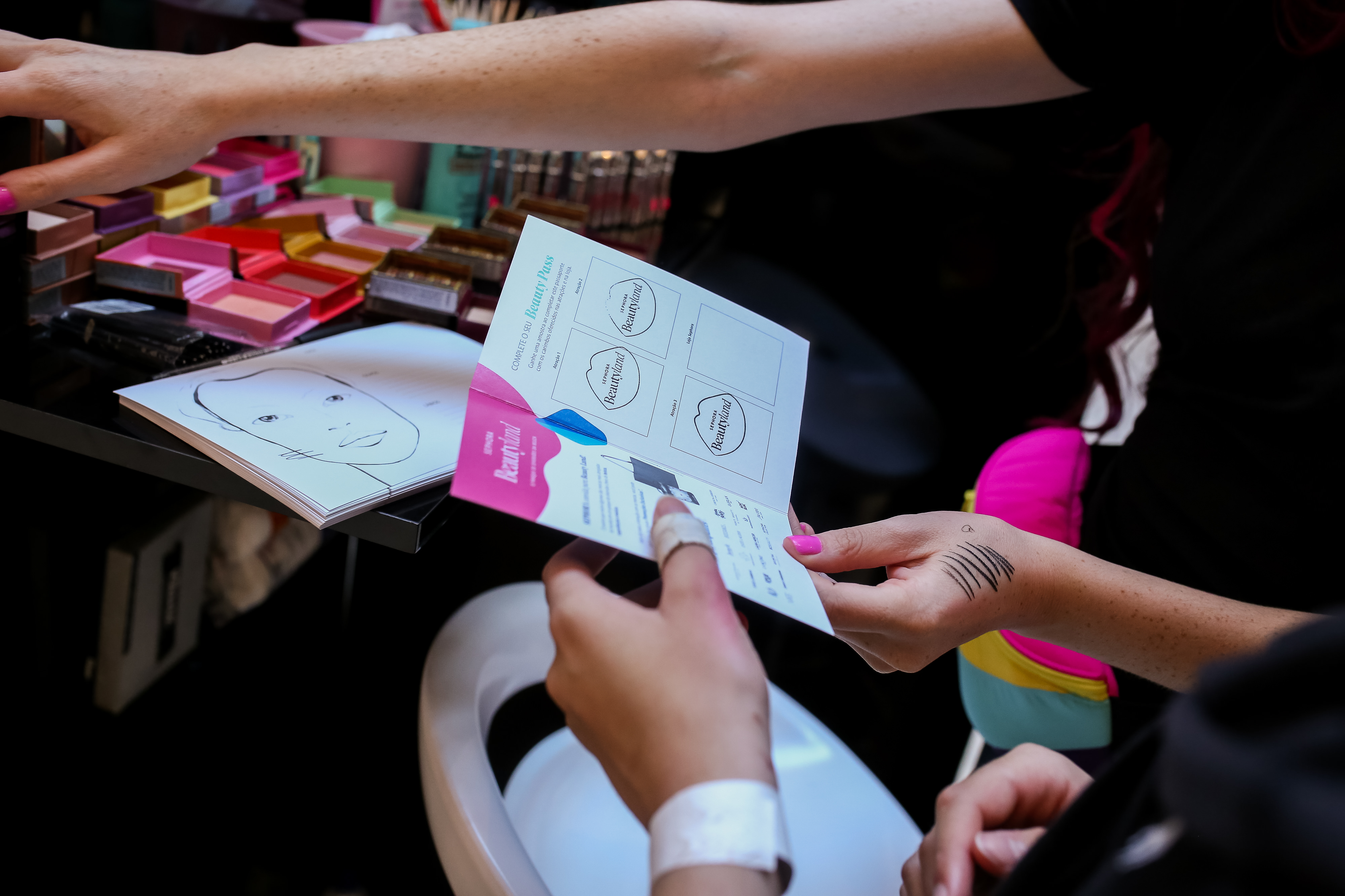 Mão segurando cartela da Sephora com carimbos de boquinhas