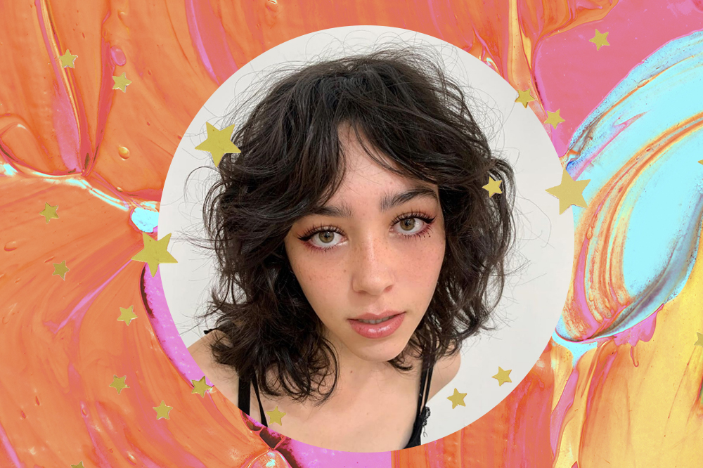 Montagem em fundo laranja, rosa e azul com estrelinhas douradas e foto em moldura circular de garota com cabelo bobcat, corte que mistura long bob e wolf cut