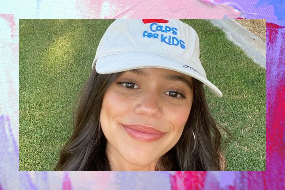 Jenna Ortega posando para foto com boné branco