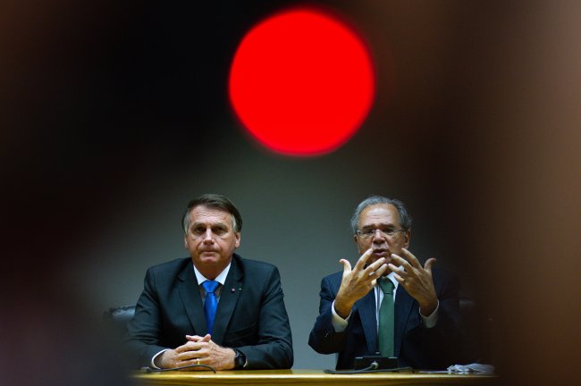 Confisco? Governo Bolsonaro faz novo corte milionário na Eduação; entenda Jair Bolsonaro e Paulo Guedes gesticulam durante palestra; ambos são homens brancos, por volta dos 60 anos