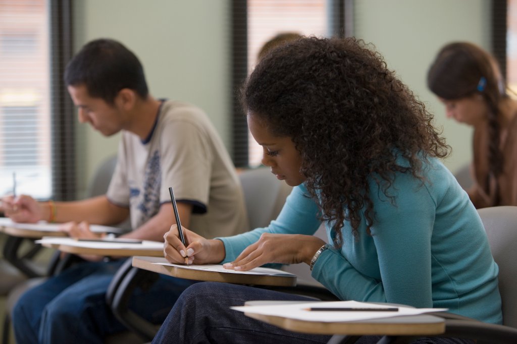 Imagem de uma sala de aula com estudantes fazendo a prova do enem.