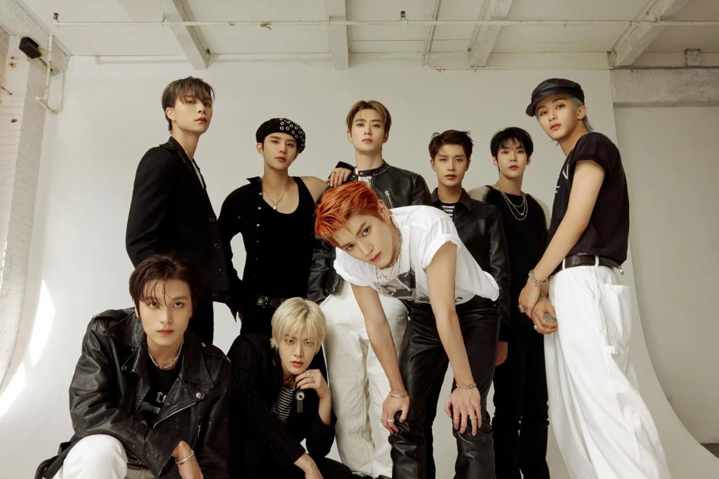 Grupo NCT 127 posando para foto em um fundo branco com expressões neutras