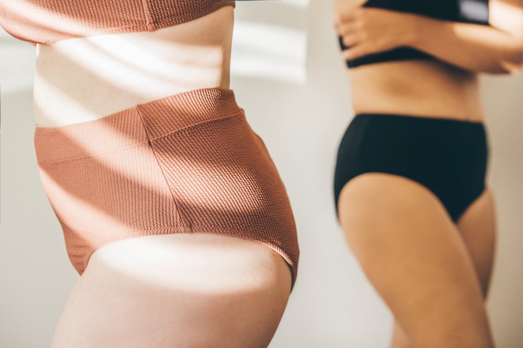 Duas mulheres vestindo calcinhas, uma marrom e outra preta