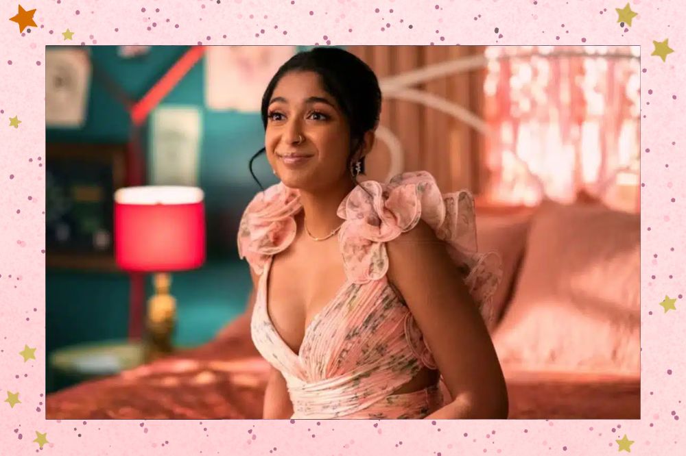 Devi de vestido rosa em seu quarto em imagem da 4ª temporada da série Eu Nunca... Fundo rosa com estrelas douradas.