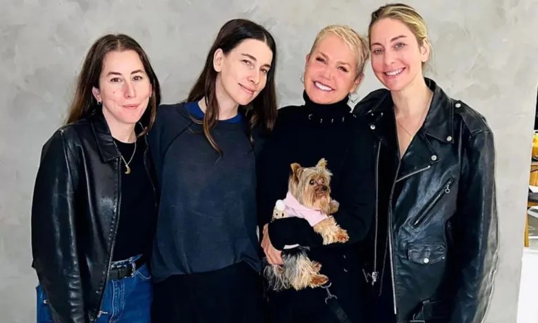 Irmãs Haim ao lado de Xuxa com seu cachorrinho na mão.