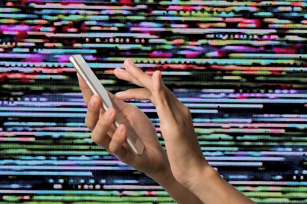 Fundo colorido e, na frente, a imagem de duas mãos mexendo em um celular