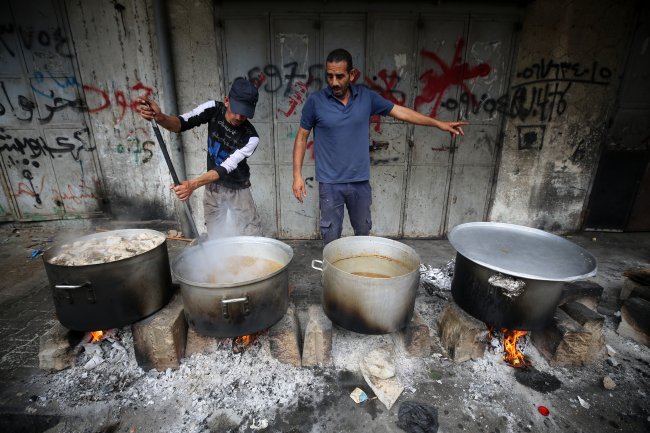 Pessoas cozinham com lenha