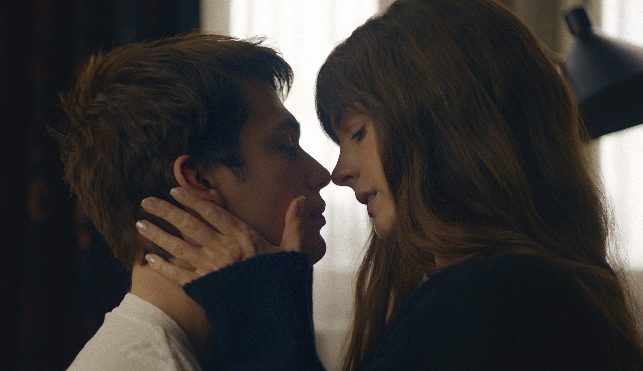 The Idea of You Anne Hathaway e Nicholas Galitzine em cena de Uma Ideia de Você; eles estão com o rosto próximo de olhos fechados e a atriz está com as mãos no rosto do ator