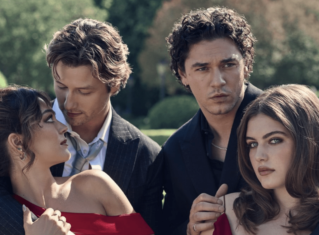 Dois homens e duas mulheres em um jardim. Um homem de terno listrado abraça uma mulher de vestido vermelho, que o olha. Outro homem de camisa preta e colar prateado, com expressão séria, está atrás de uma mulher de vestido vermelho, que olha para frente